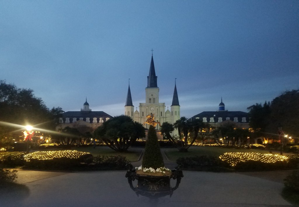 new orleans jackson square with statue and cathedral and lights at night