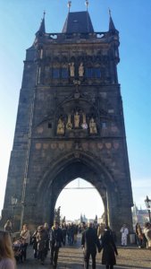 tourist crowds around an old tower on Charles Bridge in Prague, Czech Republic