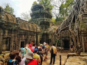 tourists in line for a photo at the famous Tomb Raider temple in Angkor, Cambodia