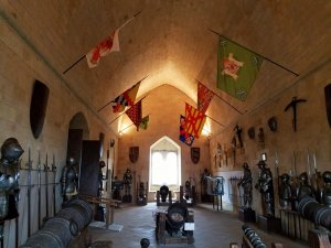Alcazar of Segovia armory room with flags, swords, cannons and suits of armor