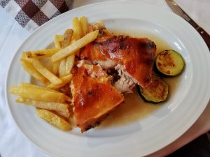 cochinillo asado racion, portion of roast pig with fries, popular with tourists on a day trip to Segovia Spain