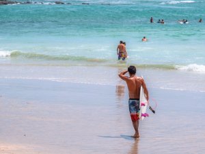 hostel guest walking to the ocean to surf
