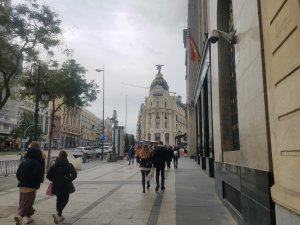 pedestrians walking in Madrid center near Metropolis building