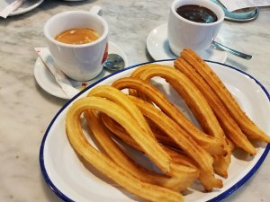 Eating Madrid churros with coffee and chocolate
