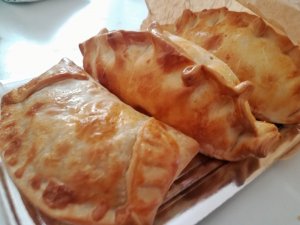 three Spanish empanadas on a plate
