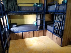 hostel dorm with bunks and curtains and lockers
