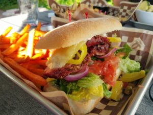 Roast pork sandwich on ciabatta bread with peppers and sweet potato fries