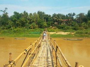 backpacking traveler on bamboo bridge in Laos before COVID-19
