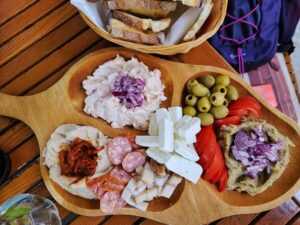 Romanian charcuterie board with sausage, cheese, olives and eggplant, bean and carp roe dips