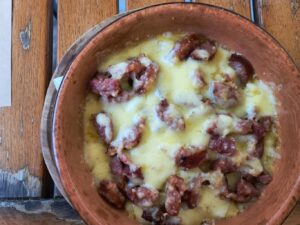 eating bowl of bulz in Brasov Romania with polenta and cheese and meat