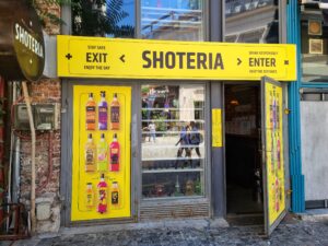Exterior of Shoteria, with a menu of options for shots of liquor in Bucharest Romania Old Town