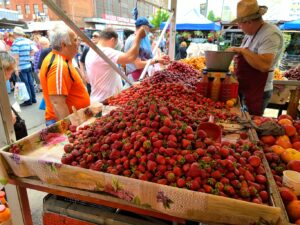 Mounds of fresh strawberries under a vendor's tent at Obor Market in Bucharest Romania