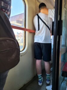 Standing room only on train in Romania with passengers standing in the corridor of the car