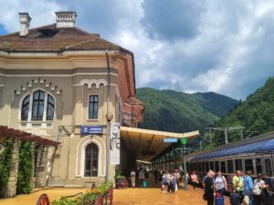 Transportation in Romania at a train station in Sinaia with tourists exiting train and on platform