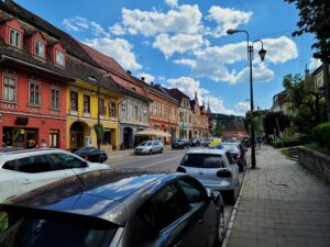Looking down busy main road in Lower Town of Sighisoara Romania with colorful buildings 