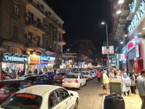busy streets at night, full of pedestrians and traffic, in Downtown Cairo